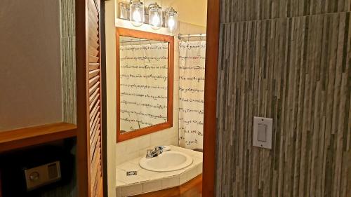 
a bathroom with a mirror, sink, and bathtub at Sunrise Club Hotel in Negril
