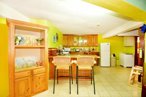 a kitchen with yellow walls and a table and chairs at Beachfront Cottage in Gros Islet