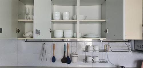 a kitchen with white cabinets and utensils at Jeju Skyline Pension in Jeju