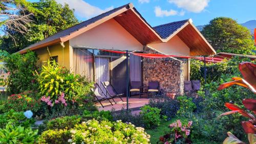 a house with a porch and chairs in a garden at Villa Alejandro in Boquete