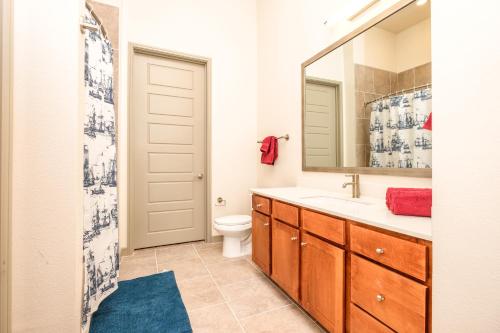 a bathroom with a toilet and a sink and a mirror at RENU at Downtown Houston in Houston