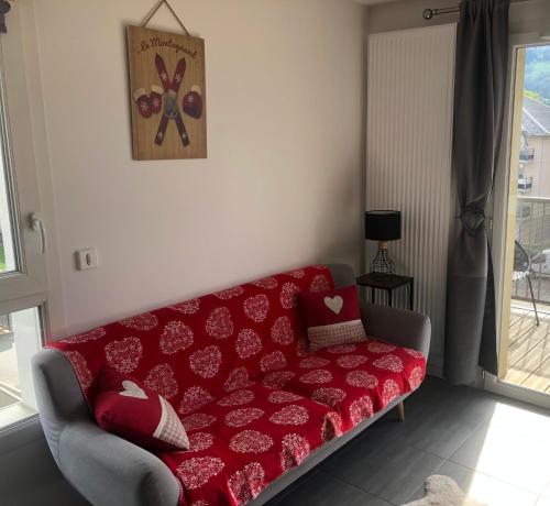 um sofá vermelho sentado numa sala de estar em Charmant appartement em Saint-Gervais-les-Bains