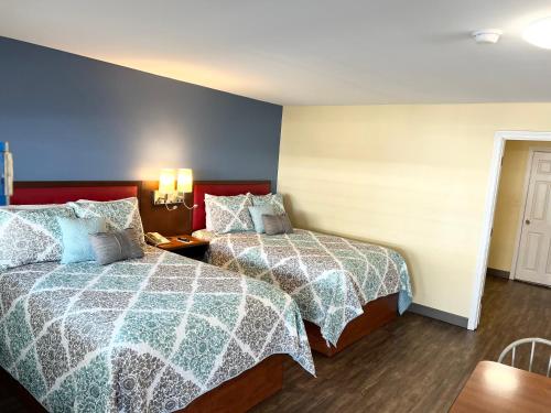 two beds in a room with blue and white blankets at Scarborough Beach Motel in Narragansett