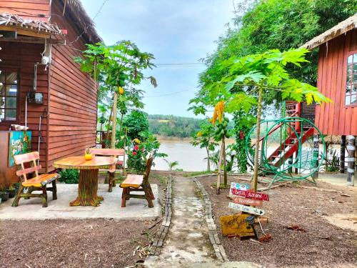 a house with a table and a playground next to a river at Betik Garden Home in Machang