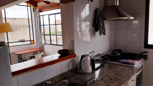 cocina con fregadero y fogones horno superior en Hermoso departamento céntrico en ultimo piso, con cochera en Salta