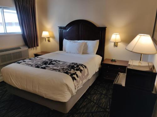 a hotel room with a large bed and a lamp at Skyline Motor Inn in Cody