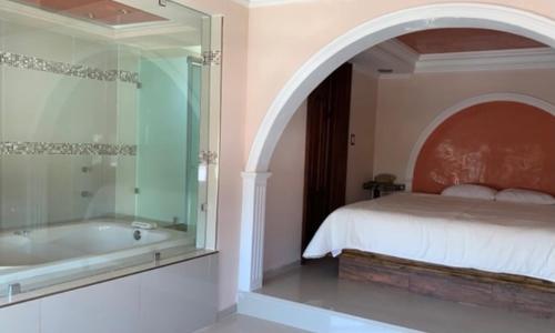 a bedroom with a bed and a bath tub at Hotel La Condesa in Huasca de Ocampo