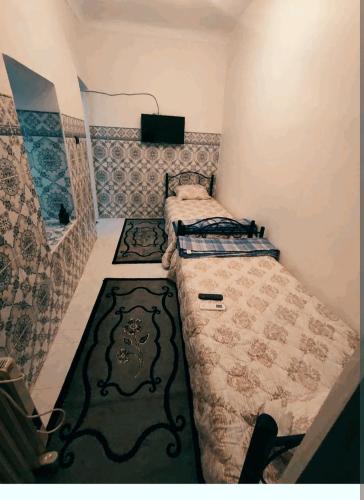 una piccola camera con letto e tappeto di Dar Beldi a Marrakech