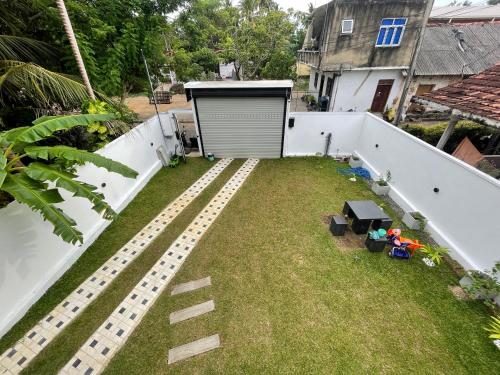 an empty backyard with a fence and grass at Jevin Villa in Weligama