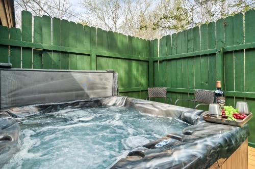 a hot tub in a backyard with a green fence at Bearly Gnomey in Gatlinburg