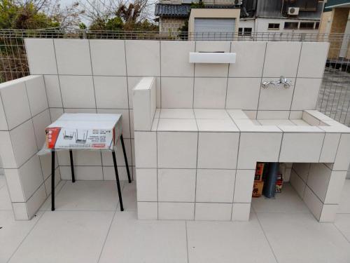 una pared de azulejos blancos con una caja sobre una mesa en Passa Tempo Awajishima Ocean - Vacation STAY 22851v, en Awaji
