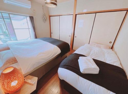 伊勢市にある民泊宿伊勢志摩205のベッド2台とテーブルが備わる小さな客室です。