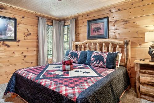 1 dormitorio con 1 cama en una cabaña de madera en Bluebearry Patch en Gatlinburg