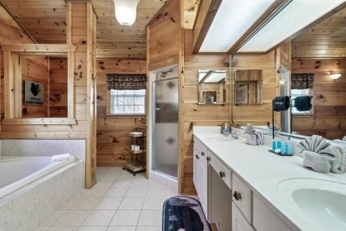 een badkamer met houten wanden, een bad en een wastafel bij Fireflies and Moonshine in Gatlinburg