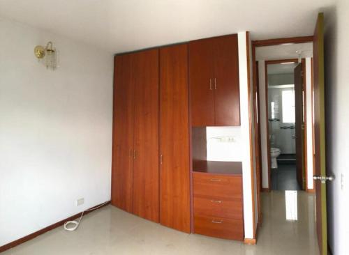een keuken met houten kasten en een spiegel bij Habitación en apartamento con ubicación estratética mejor sector sur in Cali