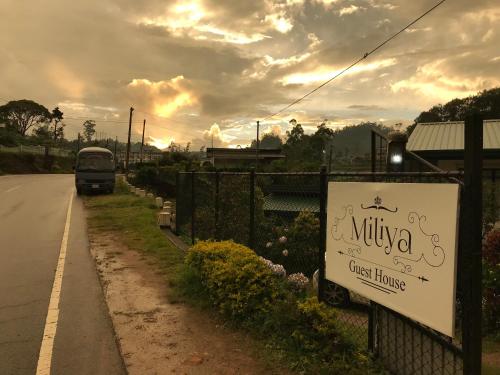 a van driving down a road with a sign on a fence at Miliya Guest House in Nuwara Eliya