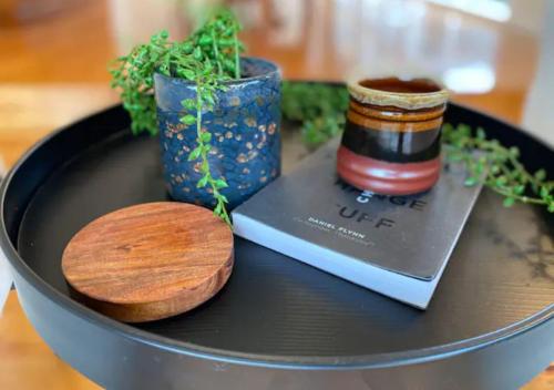 a table with a book and a vase and a wooden spoon at BerwickHills Stylish 3 BdrmHome *Free Wifi*NetFlix in Berwick