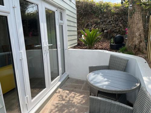 a patio with a table and chairs on a porch at Perran Pearl B in Perranporth