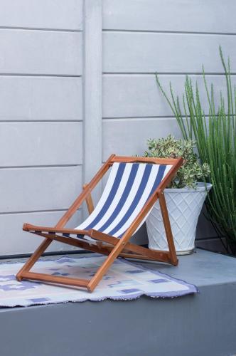 a wooden rocking chair sitting next to a potted plant at 9 Windsor House in Tokai