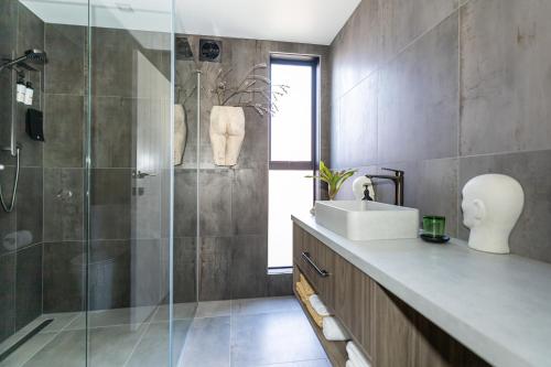 a bathroom with a sink and a glass shower at Arthouse Botanic Lake Tekapo in Lake Tekapo