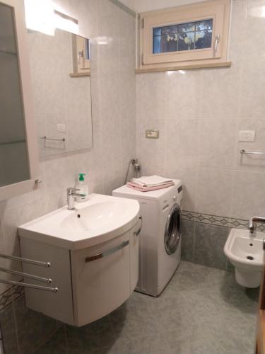 a bathroom with a washing machine and a sink at Appartamento SUNRELAX in Riva del Garda