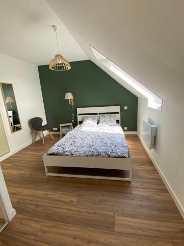 1 dormitorio con cama y pared verde en Maison joliment rénovée à 5 minutes du futuroscope, en Chasseneuil-du-Poitou
