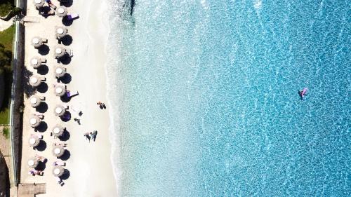 an overhead view of people on a beach with umbrellas at Hotel Stella Maris in Villasimius