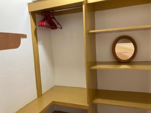 a shelf with a mirror and a red umbrella at Reynaldo's Upstairs in Puerto Galera