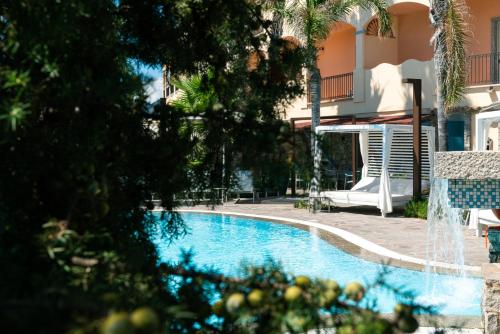 a swimming pool in front of a building at Hotel Stella Maris in Villasimius