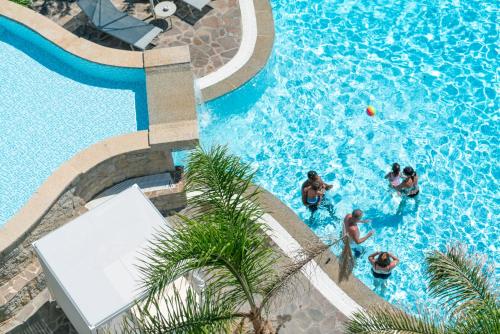 a group of people playing in a swimming pool at Hotel Stella Maris in Villasimius