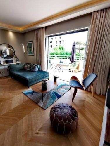 - un salon avec un canapé vert et une grande fenêtre dans l'établissement Perfect place to stay In Juan-les-Pins, à Antibes