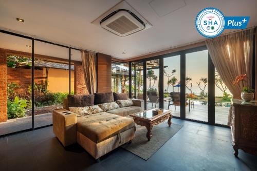 a living room with a couch and a table at Nirvana Beach Resort, Koh Lanta SHA Extra Plus in Ko Lanta