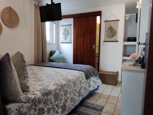 ein Schlafzimmer mit einem Bett und einem TV in der Unterkunft Manta Rota Holiday Home in Manta Rota