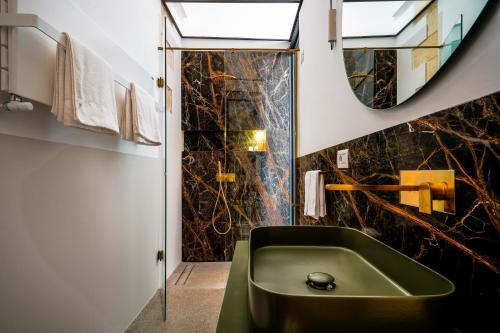 a bathroom with a green tub and a mirror at Palazzo De Noha - Boutique Hotel in Lecce