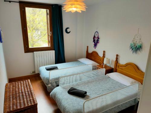 una habitación con cuatro camas y una ventana en Apartamento Diezcapanas, en Villanúa