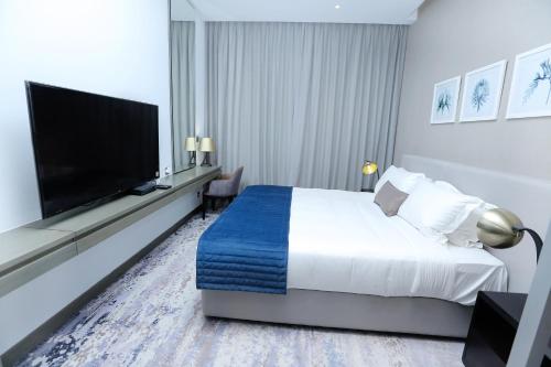 um quarto de hotel com uma cama e uma televisão de ecrã plano em DAMAC MAISON PRIVE em Dubai