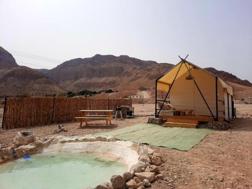 une tente dans le désert avec une piscine d'eau dans l'établissement TRANQUILO - Dead Sea Glamping, à Metsoke Dragot