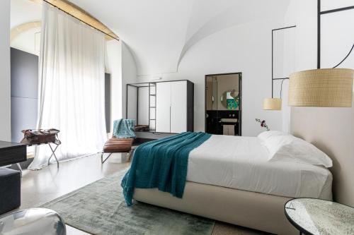 a bedroom with a bed with a blue blanket on it at Palazzo De Noha - Boutique Hotel in Lecce