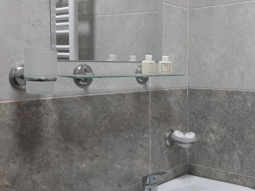 y baño con ducha, espejo y lavamanos. en Hotel Garbani, en Kazbegi