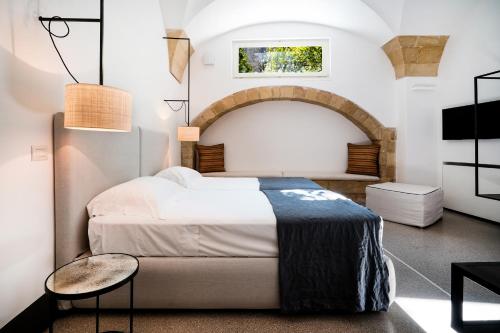 a bedroom with a large bed and a table at Palazzo De Noha - Boutique Hotel in Lecce