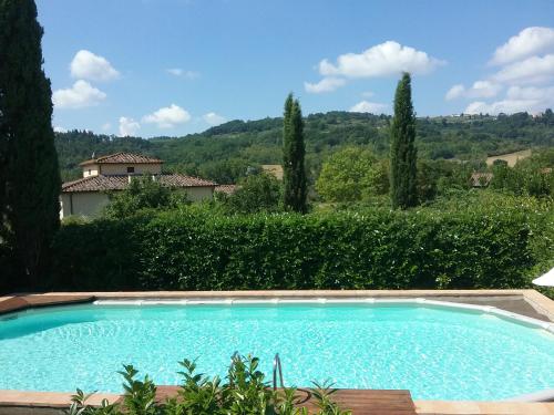 duży basen w ogrodzie z drzewami w obiekcie Casale La Fornace nel Chianti w mieście San Casciano in Val di Pesa