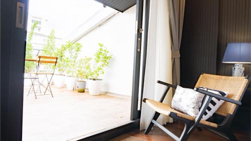 a room with a balcony with a chair and a window at BAAN 125 STAY Phuket in Phuket Town
