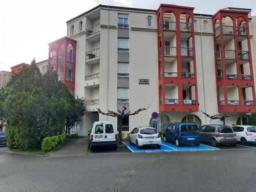 ein Parkplatz mit vor einem Gebäude geparkten Autos in der Unterkunft studio tout équipé proche therme in Lamalou-les-Bains