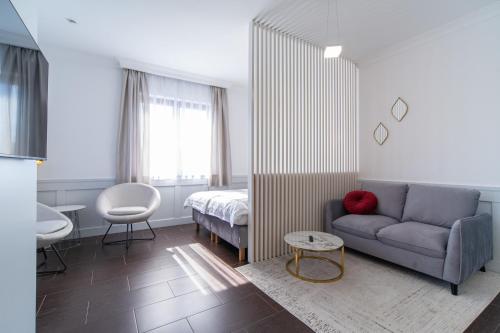 ein Wohnzimmer mit einem Sofa und einem Bett in der Unterkunft Villa Kamila in Międzywodzie