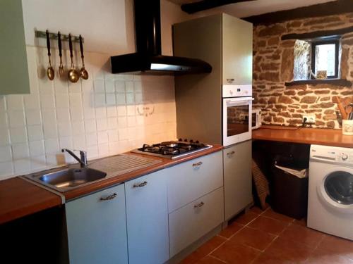 a kitchen with a sink and a stove top oven at La Belle Grange Bussiere in Bussière-Portevine