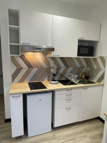 une cuisine avec des armoires blanches et un comptoir dans l'établissement Studio - Téléphérique/Gare, à Toulon