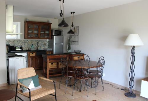 uma cozinha com uma mesa e cadeiras numa cozinha em Bastidon avec piscine Gordes Lubéron em Gordes