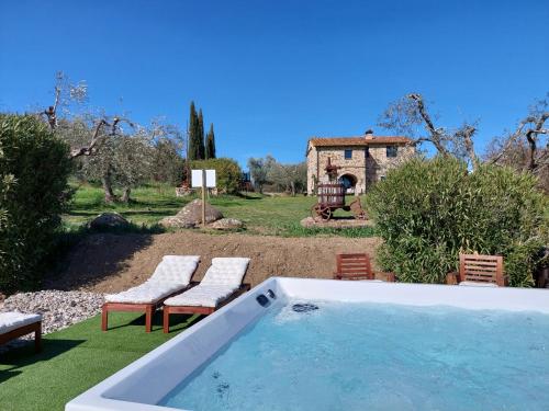 a swimming pool in a yard with chairs and a house at Casetta dell`Uliveto in Macchiascandona