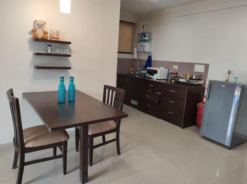 kuchnia ze stołem, krzesłami i lodówką w obiekcie 1BHK AC Service Apartment 115 w mieście Pune