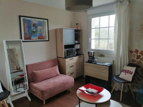 Le Torcopel في Grangues: غرفة معيشة مع أريكة وردية وطاولة